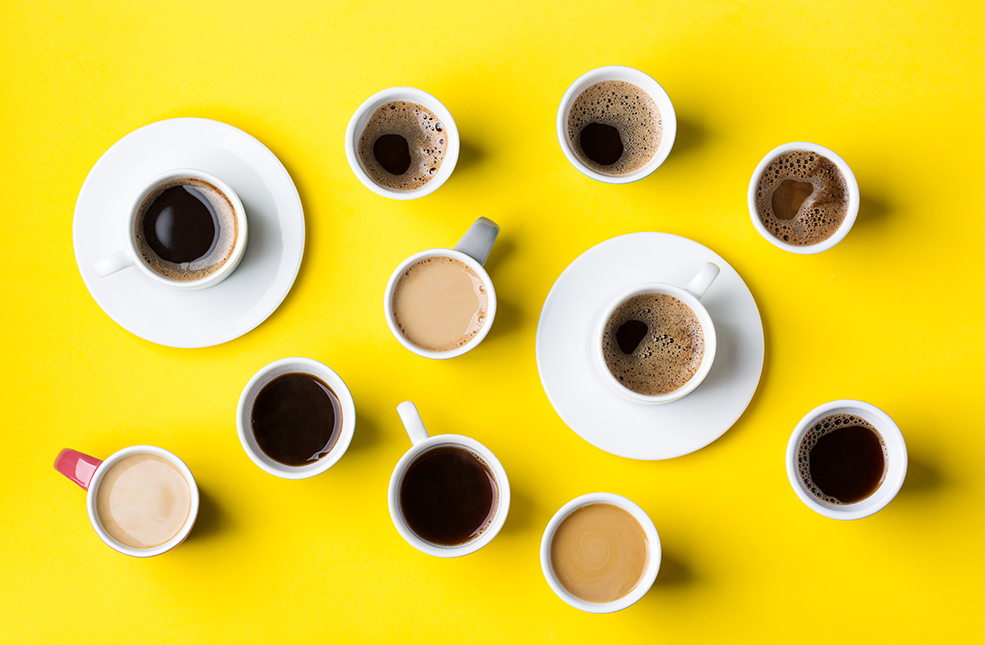 Artikelbild Viele verschiedene Kaffeetassen auf gelbem Hintergrund