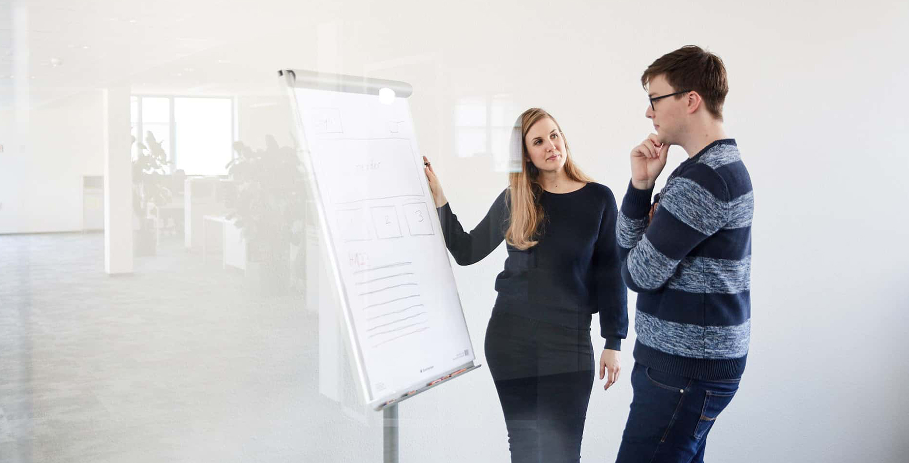 Zwei Studierende an einem Flipchart